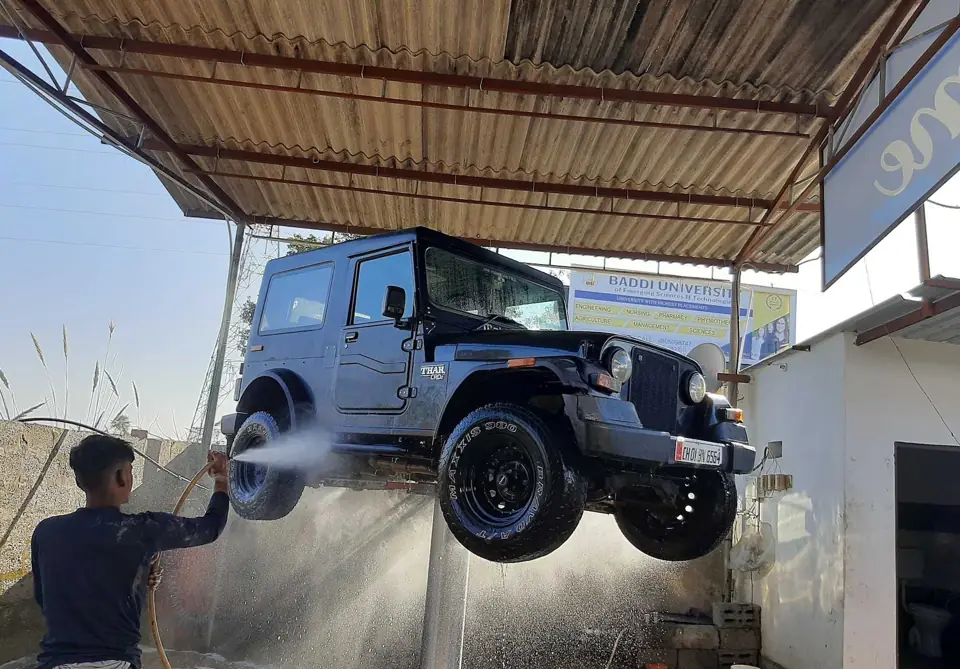 SUV raised on a lift during an underbody foam wash